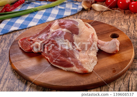 Raw Duck Leg Quarter on Rustic Wooden Board with Fresh Vegetables 139608537