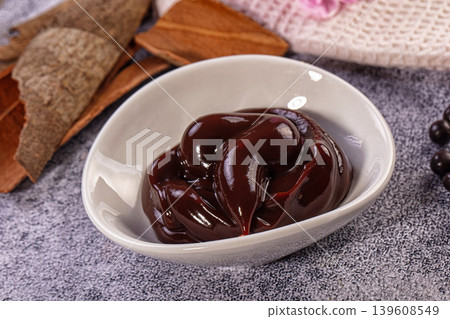 Rich chocolate ganache in white bowl, cinnamon sticks, dark berries Rich chocolate ganache in white bowl, cinnamon sticks, dark berries 139608549