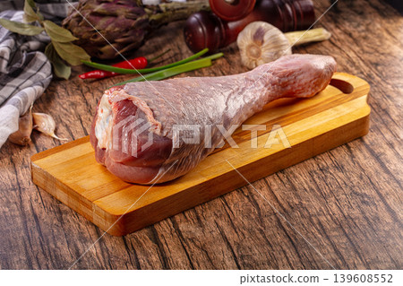 Raw turkey leg on wooden board with fresh garlic, chili peppers, and herbs Raw turkey leg on wooden board with fresh garlic, chili peppers, and herbs 139608552