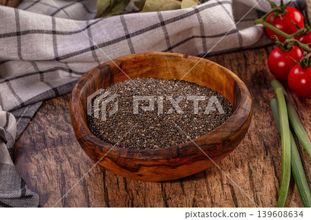 Healthy chia seeds in rustic wooden bowl, fresh cherry tomatoes, green onions, natural setting Healthy chia seeds in rustic wooden bowl, fresh cherry tomatoes, green onions, natural setting 139608634
