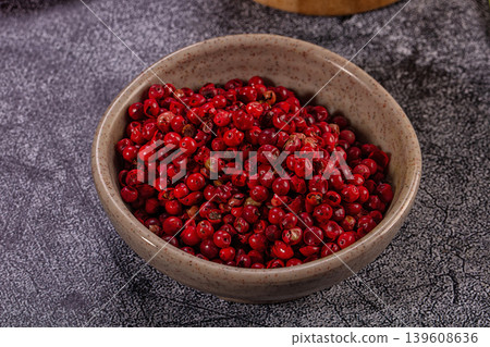 Bright red peppercorns in ceramic bowl with green onion stalks and wooden mortar Bright red peppercorns in ceramic bowl with green onion stalks and wooden mortar 139608636