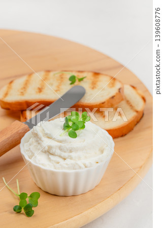 Cream cheese spread with toasted bread and knife on wooden board 139608776