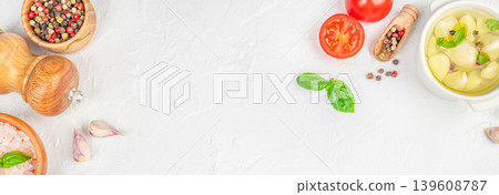 Cooking ingredients border with garlic, spices and basil on light background Cooking ingredients border with garlic, spices and basil on light background 139608787