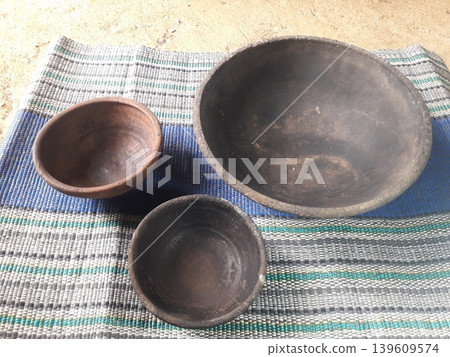 Three Different Sizes of Traditional Clay Plates on Plastic Mat Background 139609574