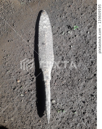 Ancient and rusty Javanese spearhead showing pitted metal texture on the ground in Indonesia. 139609595