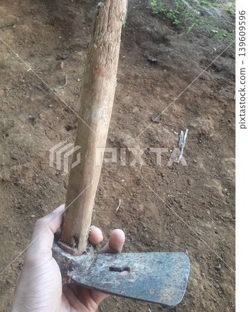 A firm grip on a vintage Indonesian Pethel, a traditional Javanese wood shaping tool, showing rusty texture 139609596