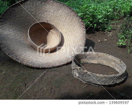 A reversed traditional farmer hat called Caping with its woven bamboo head ring in Java, Indonesia A reversed traditional farmer hat called Caping with its woven bamboo head ring in Java, Indonesia 139609597
