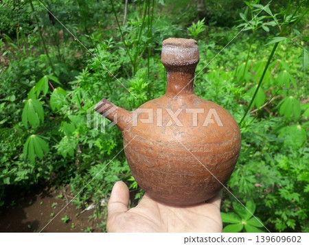 Traditional Handmade Terracotta Kendi from Java Indonesia Held by Hand Traditional Handmade Terracotta Kendi from Java Indonesia Held by Hand 139609602
