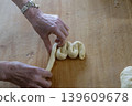 Hand Shaping Braided Dough Close Up 139609678