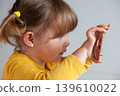 Young girl making a photo with her smartphone, exploring digital tools at early age. 139610022
