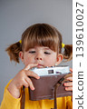 A young girl investigates an old film camera, introducing concepts such as the generation gap. 139610027