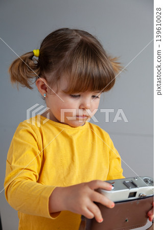 A young girl manipulates an old film camera, introducing concepts such as the analog era versus the digital era. 139610028