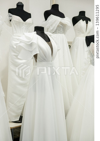 Elegant white wedding dresses display in bridal boutique with mannequins Elegant white wedding dresses display in bridal boutique with mannequins 139611295