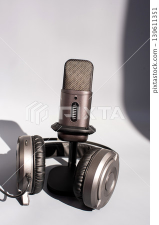 Professional microphone with headphones on minimalistic background. International Podcast Day Professional microphone with headphones on minimalistic background. International Podcast Day 139611351
