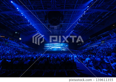 Blue live concert in arena with large crowd, stage lights and immersive visual display Blue live concert in arena with large crowd, stage lights and immersive visual display 139611355