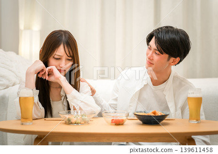 一位女士在餐桌上情緒低落,一位男士關切地和她說話。 一位女士在餐桌上情緒低落,一位男士關切地和她說話。 139611458
