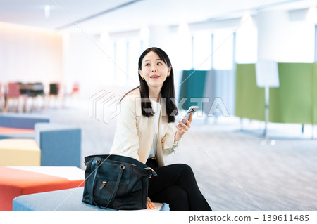 一位女士在客戶家中使用智慧型手機。 139611485