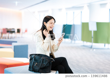 一位女士在客戶家中使用智慧型手機。 139611486
