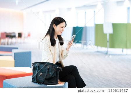 A woman using her smartphone at a client's home. A woman using her smartphone at a client's home. 139611487
