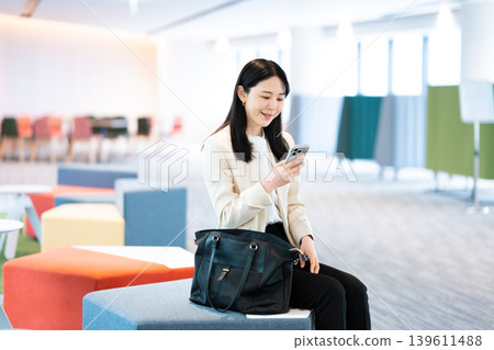A woman using her smartphone at a client's home. A woman using her smartphone at a client's home. 139611488