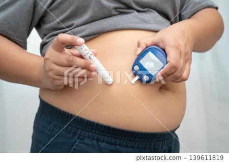 Asian woman injecting herself diabetes injecting insulin in stomach at home. Asian woman injecting herself diabetes injecting insulin in stomach at home. 139611819