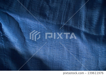 Colorful fabric draped softly on a surface showing various shades of purple and blue in natural light 139611976
