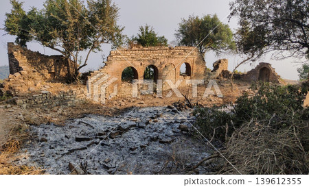 Historic temple remains at tilla jogian pakistan show old archways behind grey fire ash Historic temple remains at tilla jogian pakistan show old archways behind grey fire ash 139612355