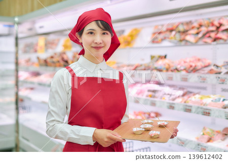 A young woman working at a supermarket's sample counter A young woman working at a supermarket's sample counter 139612402