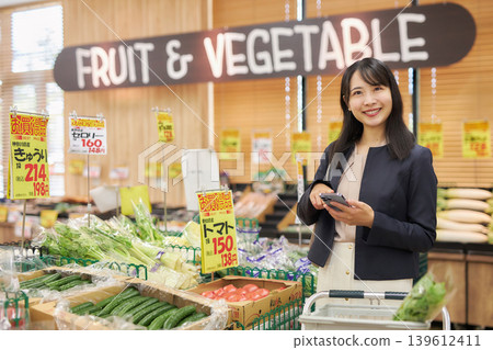 A young woman shopping at a supermarket on her way home from work. 139612411