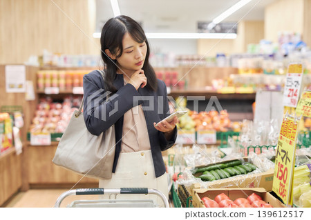 A young woman shopping at a supermarket on her way home from work. 139612517