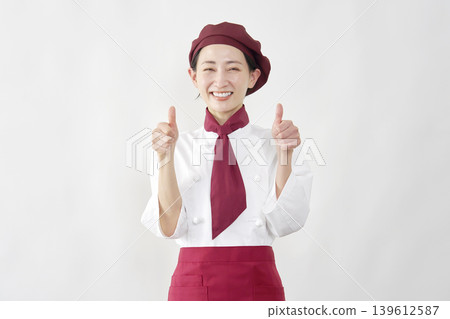 A female pastry chef gives a thumbs-up. A female pastry chef gives a thumbs-up. 139612587