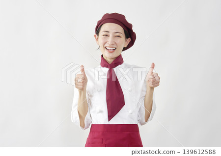 A female pastry chef gives a thumbs-up. A female pastry chef gives a thumbs-up. 139612588