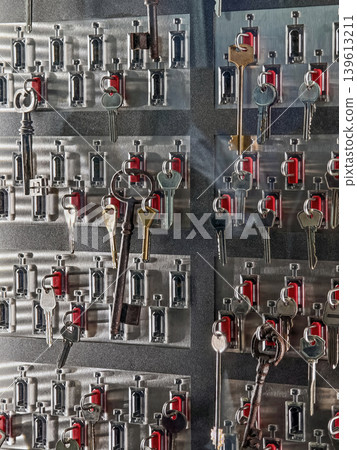 Collection of keys displayed on a board in a storage area for identification and organization during the day 139613211