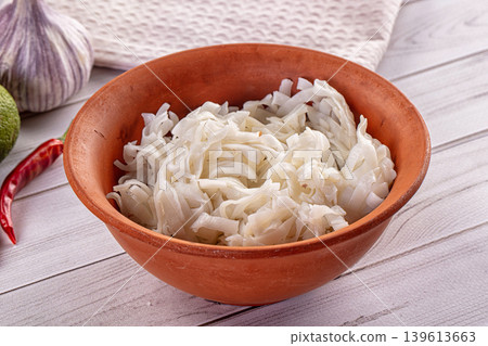 Cooking preparation with Asian rice noodles in a clay bowl and fresh ingredients. Cooking preparation with Asian rice noodles in a clay bowl and fresh ingredients. 139613663