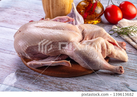 Raw duck carcass on a wooden cutting board with fresh ingredients for cooking Raw duck carcass on a wooden cutting board with fresh ingredients for cooking 139613682