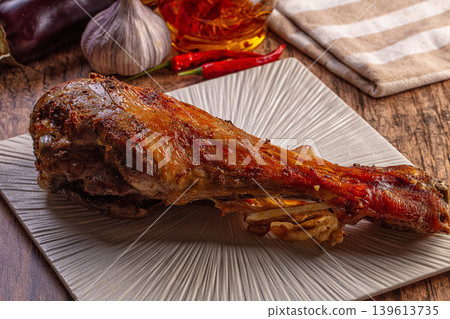 Roasted lamb shank with garlic and herbs on rustic wooden table Roasted lamb shank with garlic and herbs on rustic wooden table 139613735