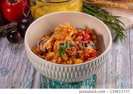 Couscous with vegetables in white bowl on rustic wooden table Couscous with vegetables in white bowl on rustic wooden table 139613737