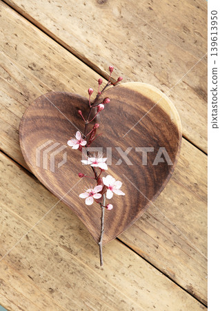 Heart Shaped Wooden Plate with Cherry Blossom on Rustic Table Heart Shaped Wooden Plate with Cherry Blossom on Rustic Table 139613950