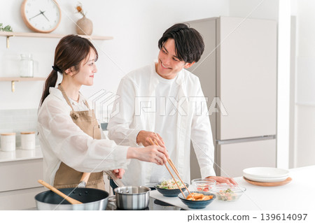 一對年輕的亞洲夫婦在家裡的廚房做飯。 一對年輕的亞洲夫婦在家裡的廚房做飯。 139614097