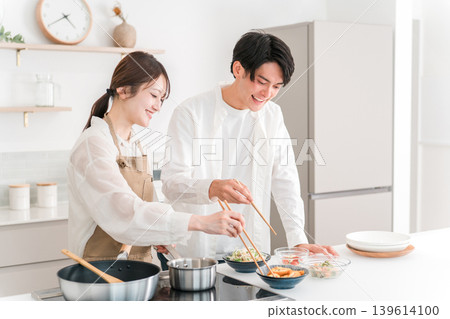 一對年輕的亞洲夫婦在家裡的廚房做飯。 139614100
