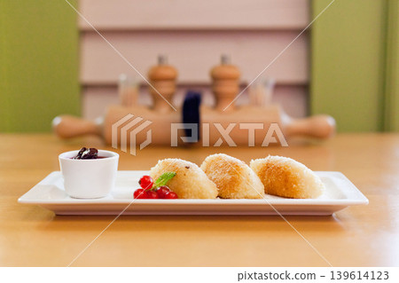Fried cheese or potato dumplings with berry jam and redcurrant garnish Fried cheese or potato dumplings with berry jam and redcurrant garnish 139614123