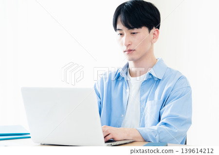 A young man who operates a computer A young man who operates a computer 139614212