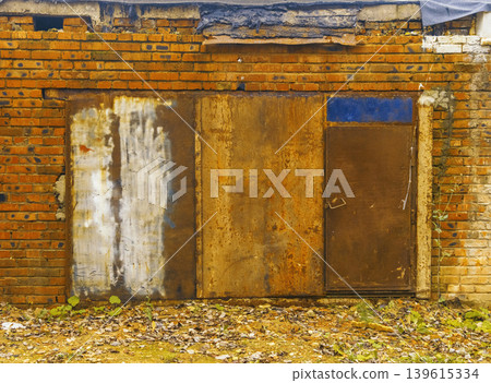 Weathered structure with peeling paint. Rundown edifice showcasing faded paint and corroded fixtures Weathered structure with peeling paint. Rundown edifice showcasing faded paint and corroded fixtures 139615334