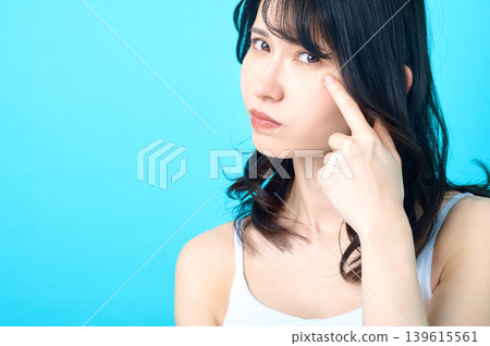 一位表情嚴肅的日本女性在接受皮膚檢查時,用手指輕撫臉頰。 一位表情嚴肅的日本女性在接受皮膚檢查時,用手指輕撫臉頰。 139615561