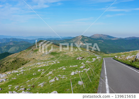 A scenic road and karst landscape running through the Shikoku Karst under a clear blue sky A scenic road and karst landscape running through the Shikoku Karst under a clear blue sky 139615658