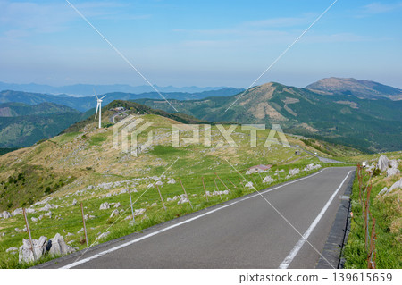 A scenic road and karst landscape running through the Shikoku Karst under a clear blue sky A scenic road and karst landscape running through the Shikoku Karst under a clear blue sky 139615659