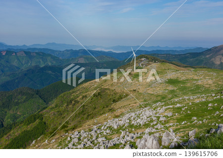 A spectacular view of the limestone formations of the Shikoku Karst and windmills standing amidst the grasslands. A spectacular view of the limestone formations of the Shikoku Karst and windmills standing amidst the grasslands. 139615706