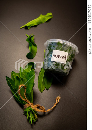 Organic sorrel bundle and fresh leaves on black backdrop Organic sorrel bundle and fresh leaves on black backdrop 139617072