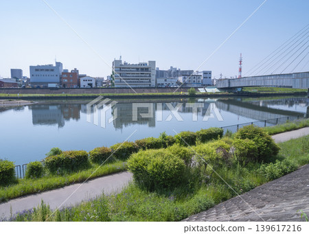 A calm river surface and a townscape along the river. A calm river surface and a townscape along the river. 139617216