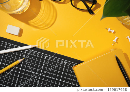 Workspace with notebook, pencils, glasses and cutting mat on bright background. Planning and productivity with copyspace Workspace with notebook, pencils, glasses and cutting mat on bright background. Planning and productivity with copyspace 139617638